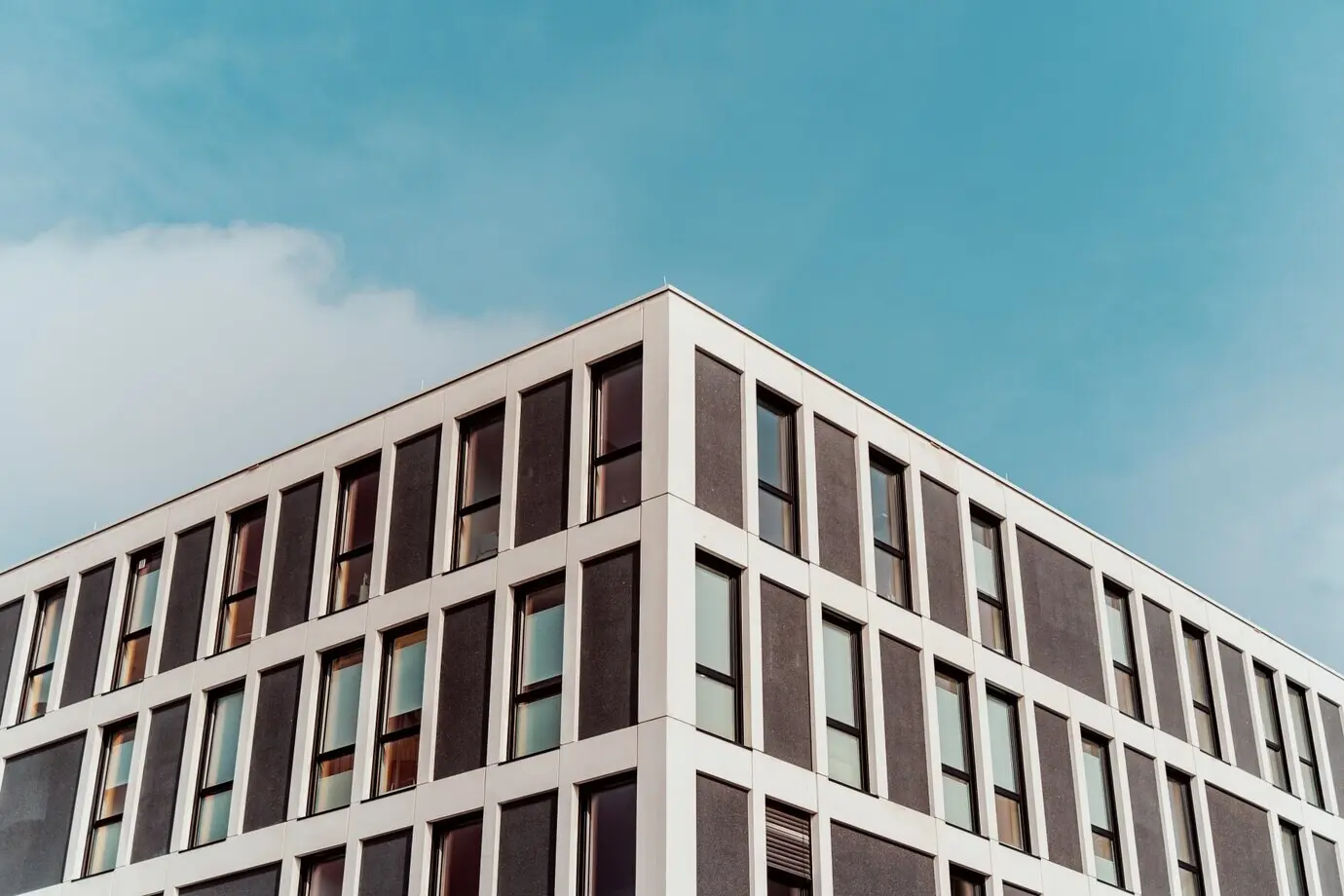 Symmetrische Aufnahme aus der Froschperspektive von alter Architektur mit schönem blauem Himmel im Hintergrund.